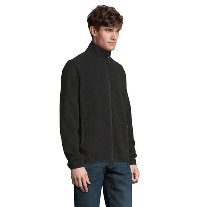 Hombre posando de perfil con chaqueta polar negra con cremallare completa