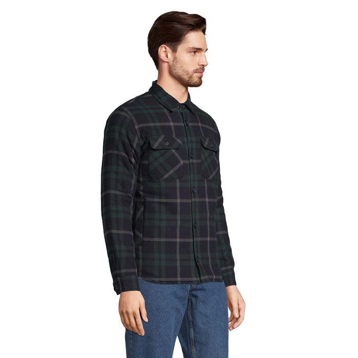 Vista lateral de hombre con sobrecamisa de cuadros oscuros