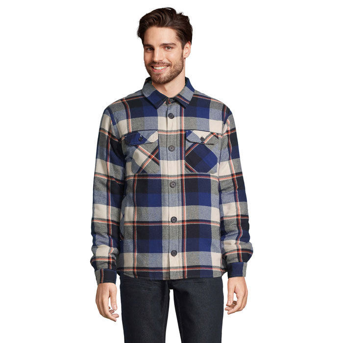 Hombre con sobrecamisa de cuadros azules y beige, cuello camisero y bolsillos delanteros