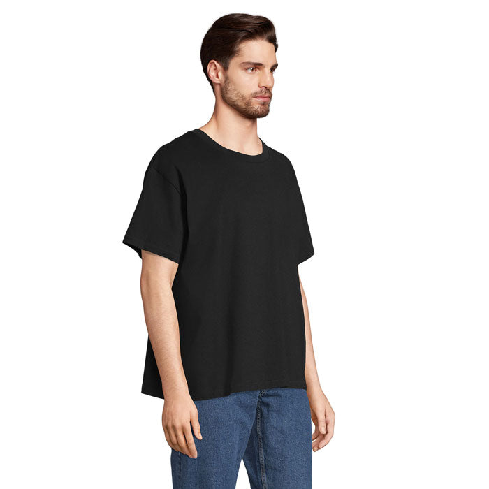Camiseta oversize en color negro, corte amplio y cuello redondo, modelo usando jeans.