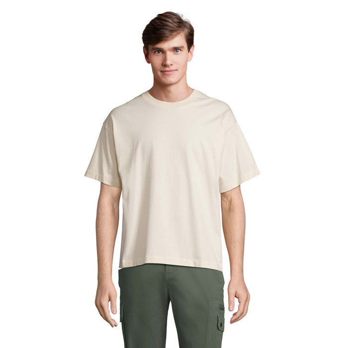 Camiseta oversize en color natural, confeccionada en materiales reciclados, vista frontal en modelo masculino.