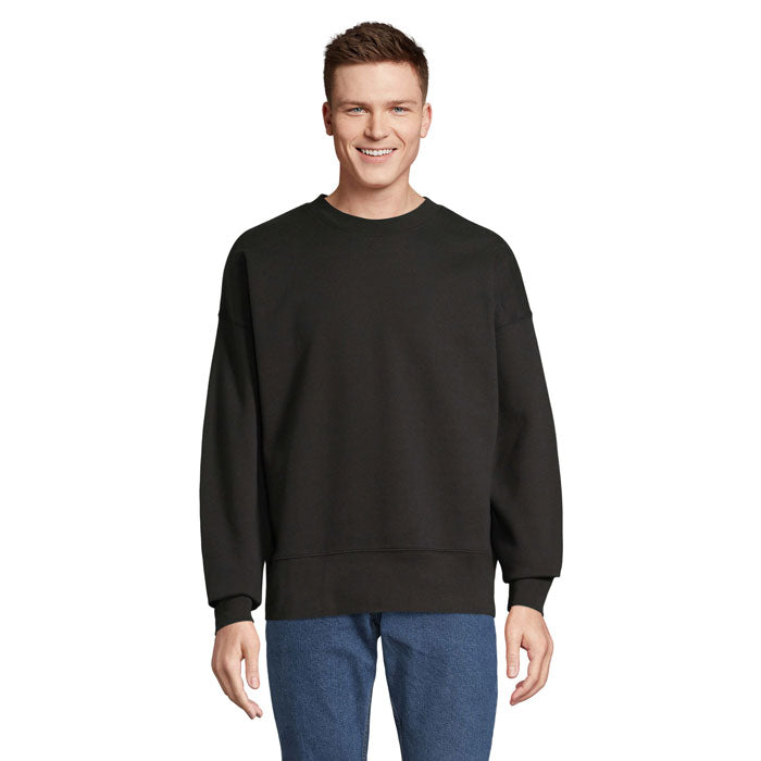 Modelo con sudadera negra oversize de cuello redondo y mangas largas
