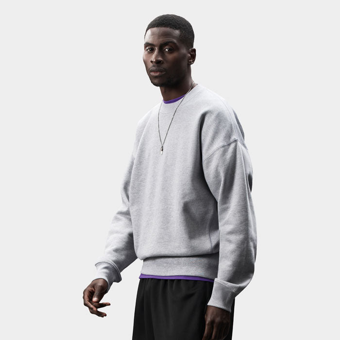 Modelo de perfil con sudadera gris claro de corte oversize