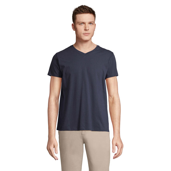 Modelo masculino de camiseta en color azul marino, con cuello en V y manga corta, fabricada en 100% algodón, vista frontal.