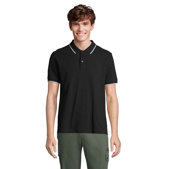 Hombre sonriente usando la PALERMO CAMISETA POLO negra con cuello blanco en contraste.