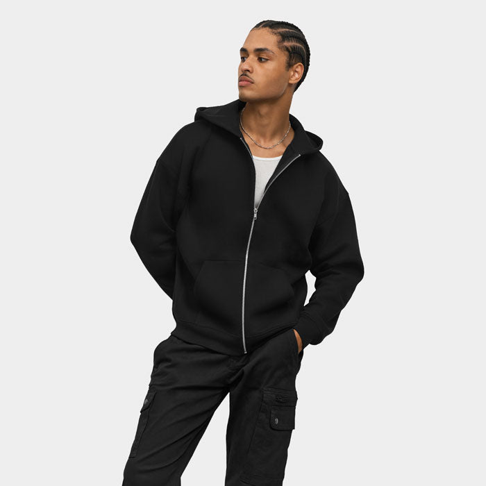 Modelo con sudadera negra de cremallera y pantalones oscuros