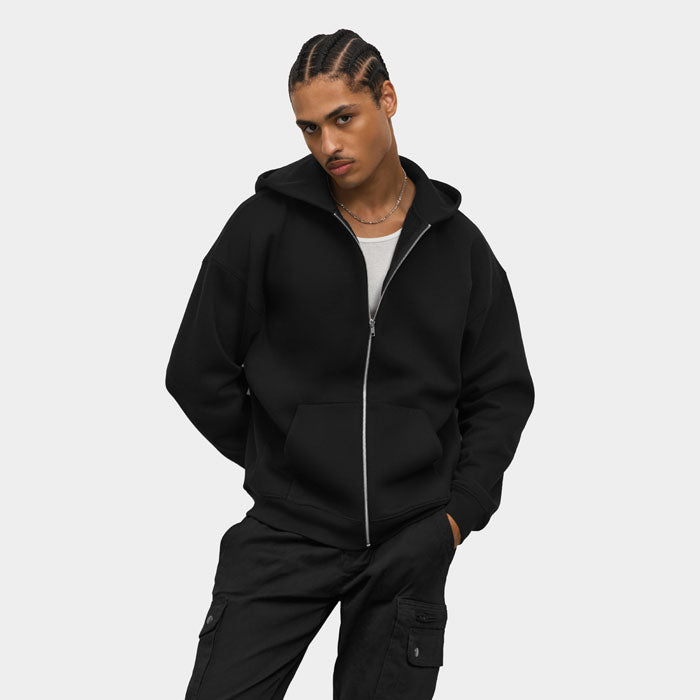 Modelo con sudadera negra de capucha y manos en los bolsillos