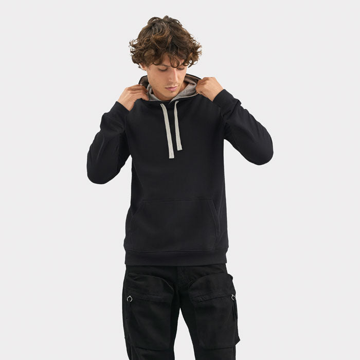 Modelo con sudadera negra con capucha, cordones claros y bolsillo canguro