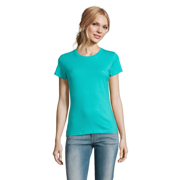 Mujer usando una camiseta de mujer en color aqua, de corte clásico y manga corta, con jeans.