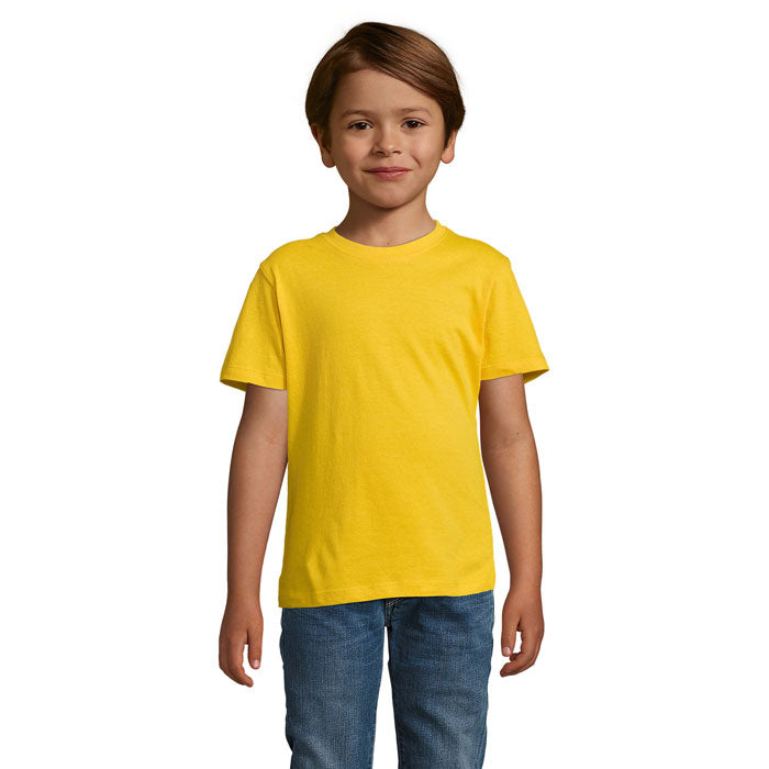 Niño sonriente con camiseta amarilla de algodón y pantalones vaqueros, ideal para uso diario y comodidad.