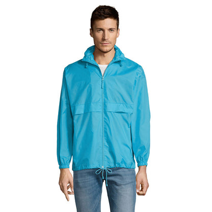 Hombre con chaqueta impermeable azul y capucha plegada, vista frontal.