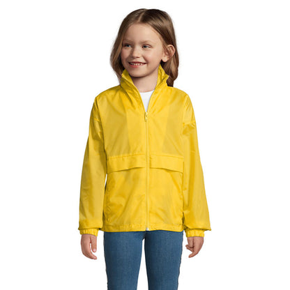 Imagen frontal de niña llevando cortavientos amarillo , manga larga.